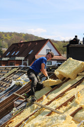 Julian neu bei der Dachdämmung eines Hauses mit Dämmmaterial
