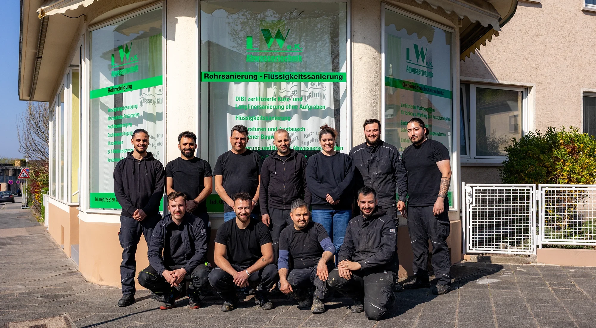 Teamfoto vor einem Geschäft für Rohrsanierung und Flüssigkeitssanierung