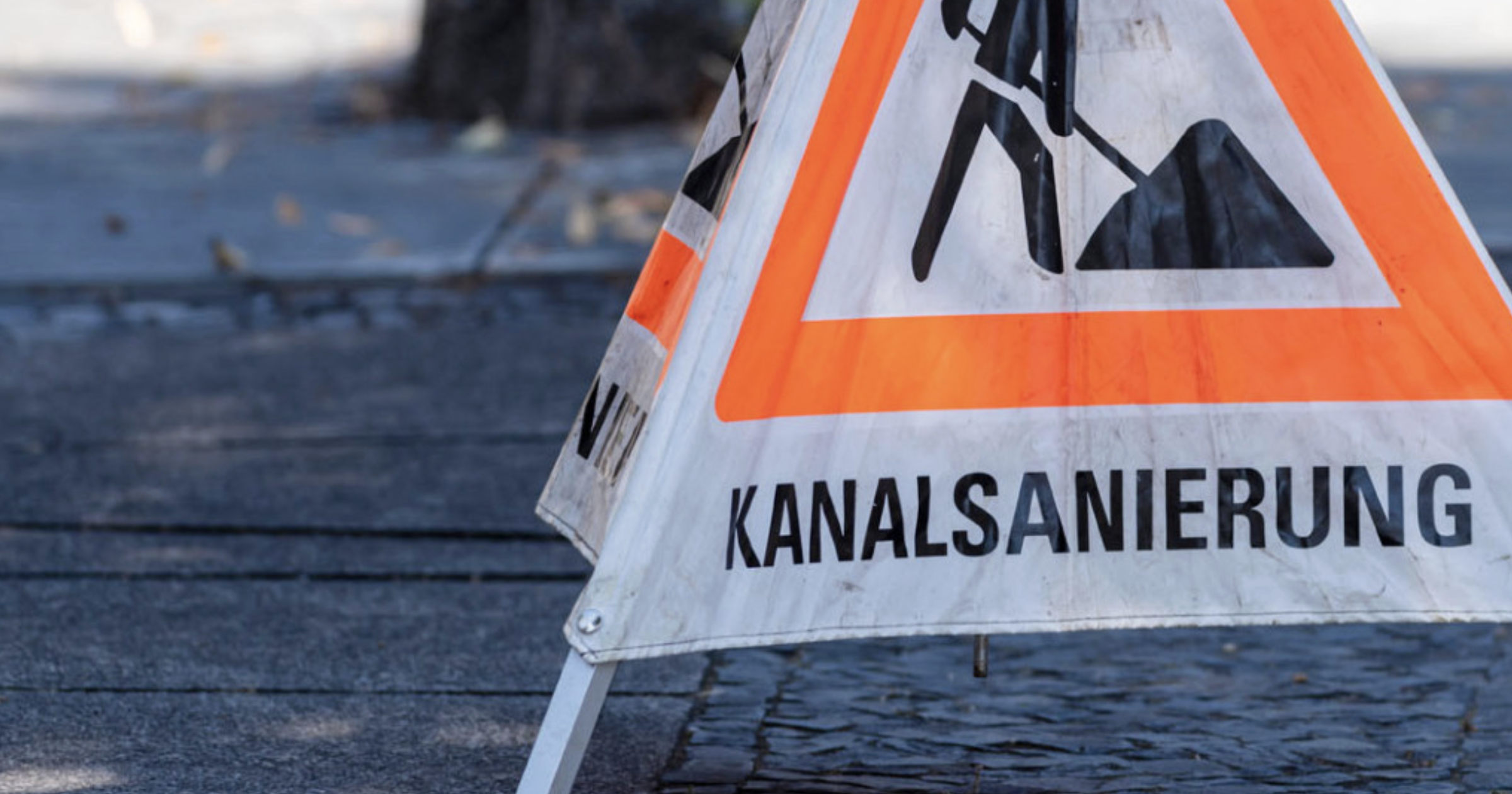 Warnschild zur Kanalsanierung auf einer Baustelle