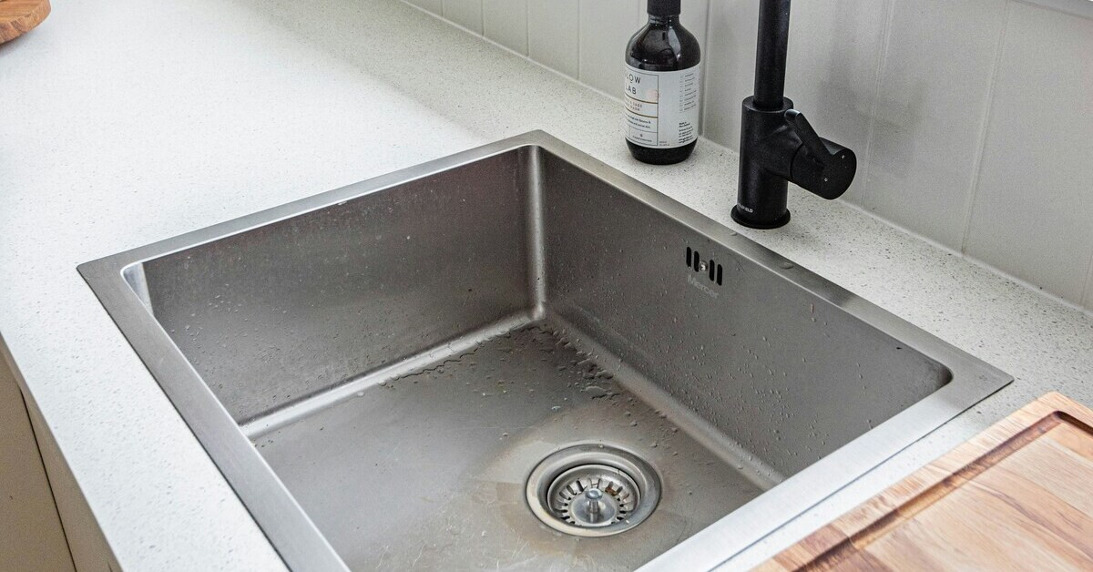 Modernes Edelstahl-Waschbecken mit Wasserhahn in einer Küche