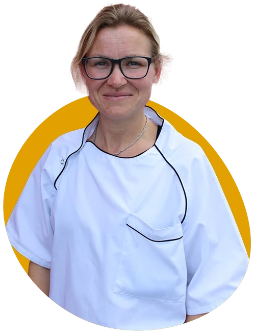 Michaela Festor aus Stein in weißer Berufskleidung vor gelbem Hintergrund