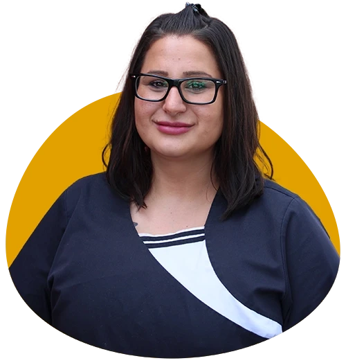 Aycan Ustaoglu in Berufskleidung vor gelbem Hintergrund