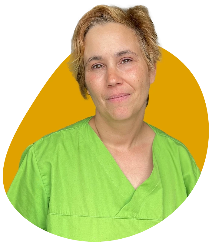 Rafika Relassi in grüner medizinischer Kleidung vor gelbem Hintergrund