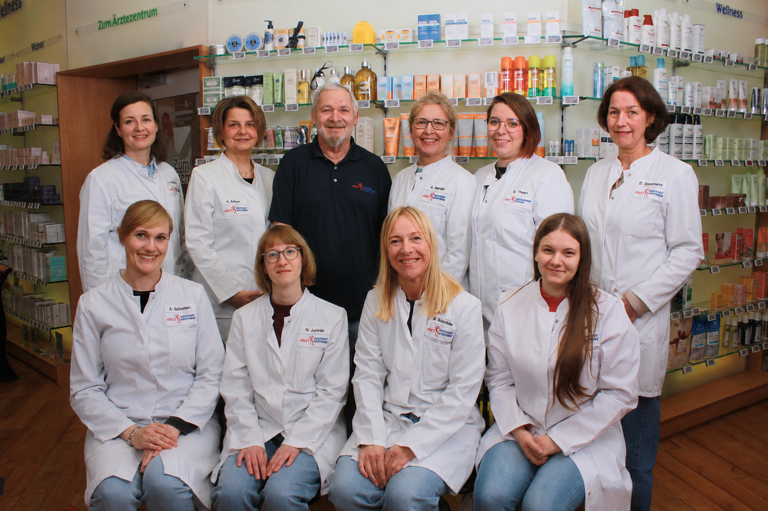 Team Oststadt in weißen Kitteln vor Apothekenregal