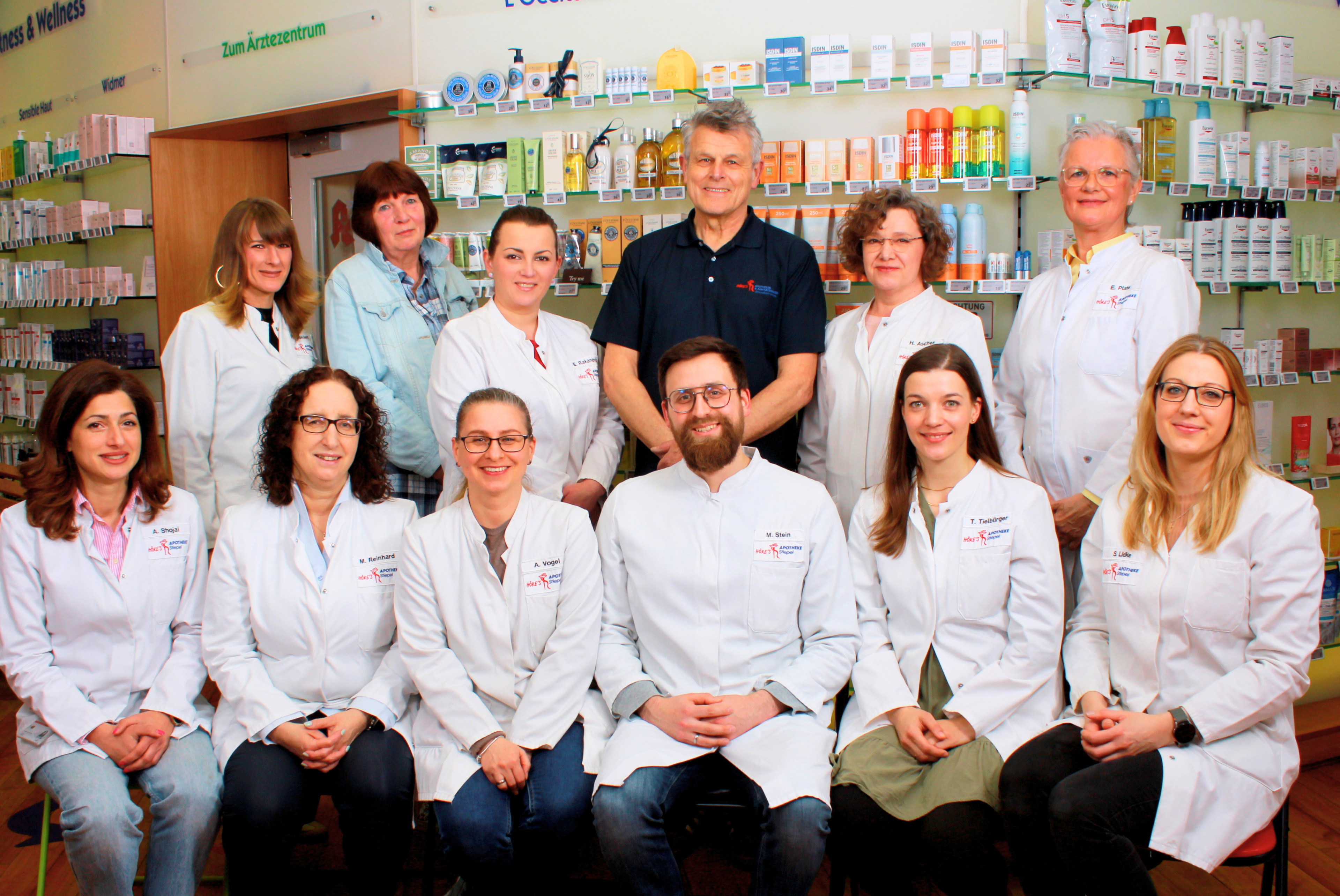 Team der Apotheke Stiepel vor dem Verkaufsregal, Gruppenfoto mit Mitarbeitern in weißen Kitteln