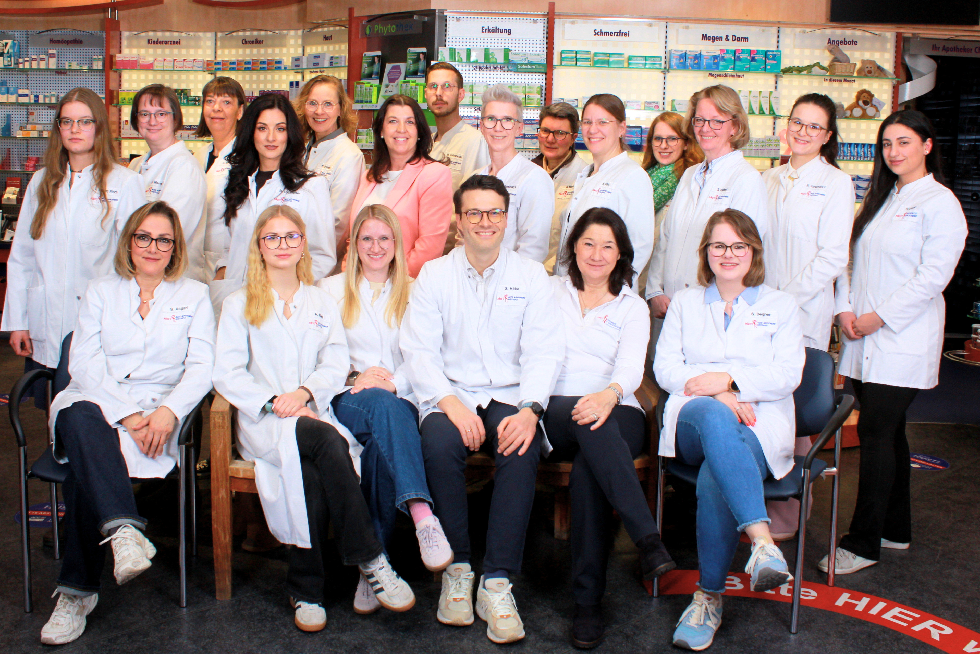 Teamfoto des Apotheken-Teams Weitmar vor den Medikamentenregalen