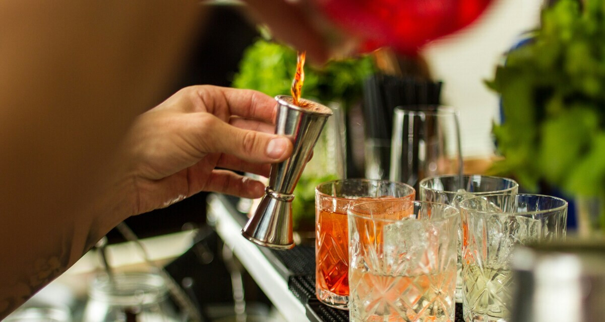 Alkoholfreie Getränke mixen – Barkeeper misst Zutaten für bunte alkoholfreie Cocktails ab