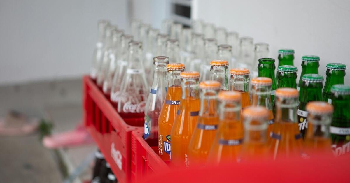 Softdrinks in Glasflaschen, darunter Fanta und Coca-Cola, in einer roten Getränkekiste