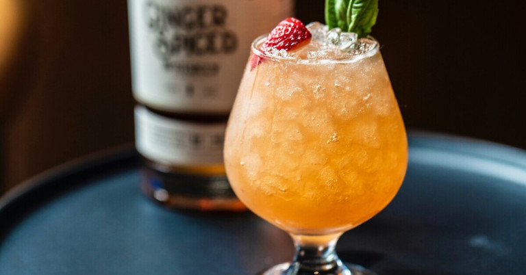 Erfrischender Drink mit Crushed Ice, garniert mit Erdbeere und Minze im Glas