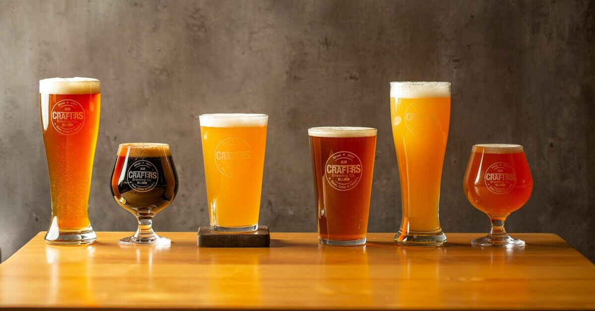 Verschiedene Biergläser mit unterschiedlichen Biersorten auf einem Holztisch