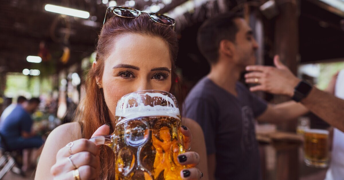 Frau genießt ein kaltes Bier im Biergarten