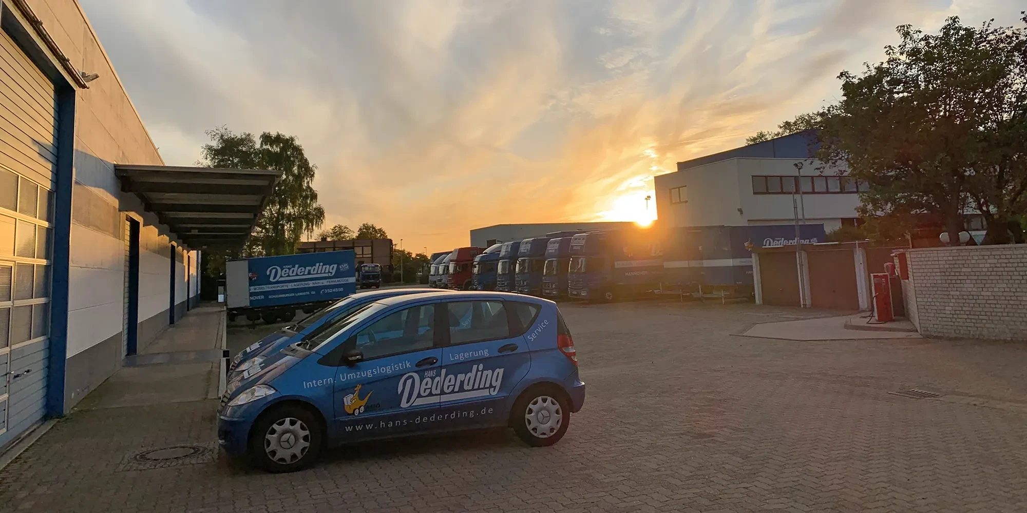 Fuhrpark von Hans Dederding Umzugslogistik bei Sonnenaufgang vor dem Firmengebäude