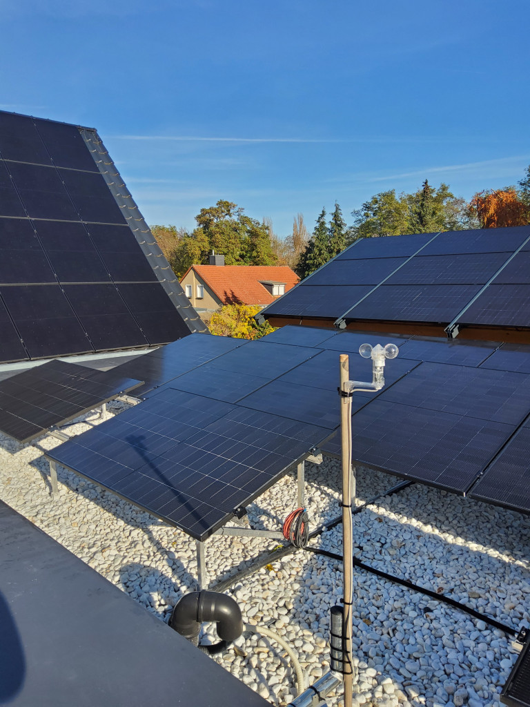 Photovoltaikanlage auf Hausdach mit Solarpanels und Messgerät bei sonnigem Wetter Photovoltaikanlage auf Hausdach mit Solarpanels bei sonnigem Wetter