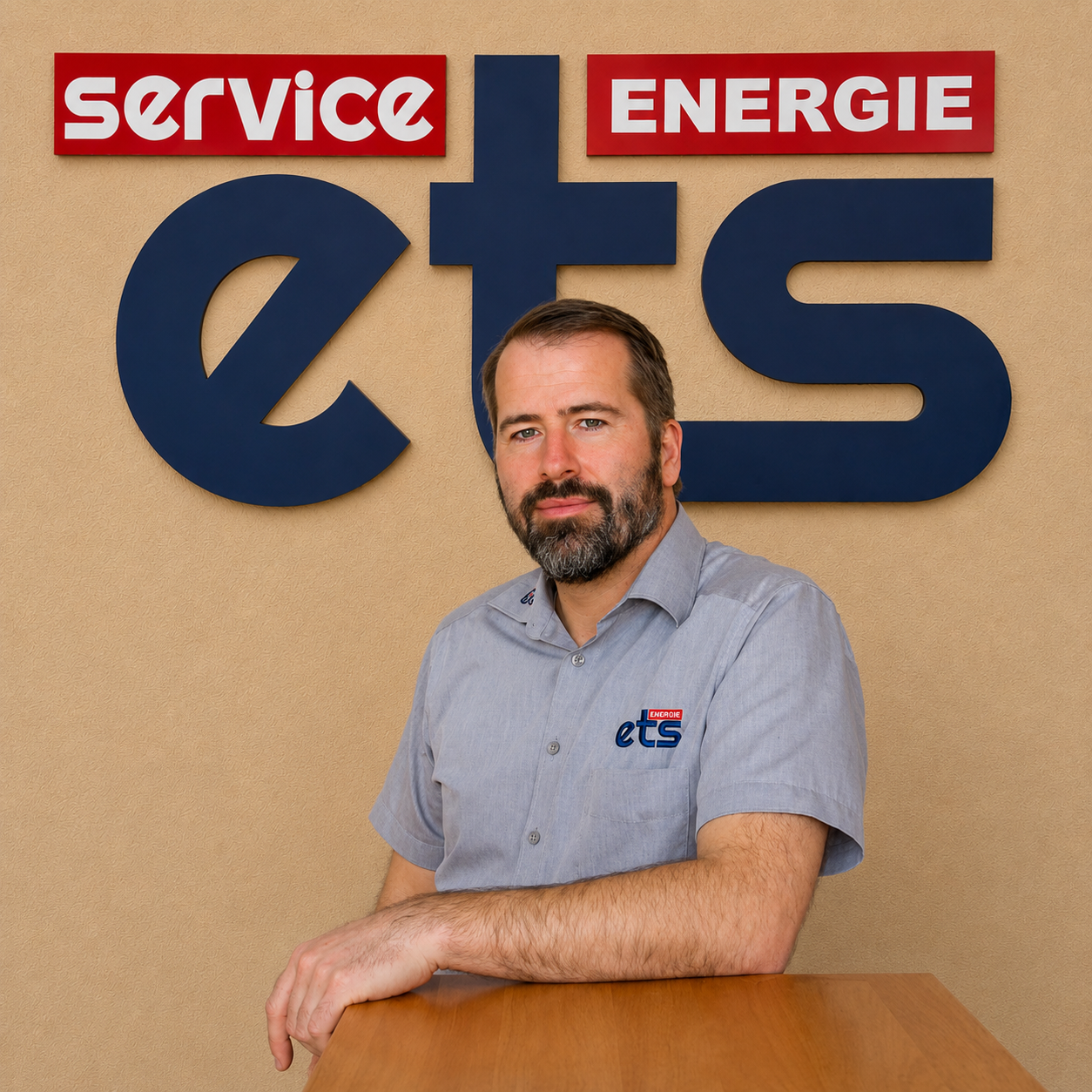Mitarbeiter von ets Energie Service vor Firmenlogo an der Wand