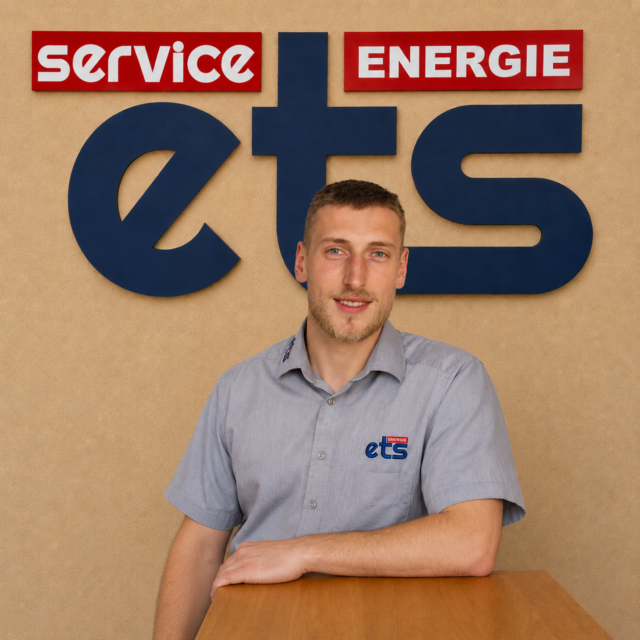 Mitarbeiter von ets Energie Service vor Logo-Wand