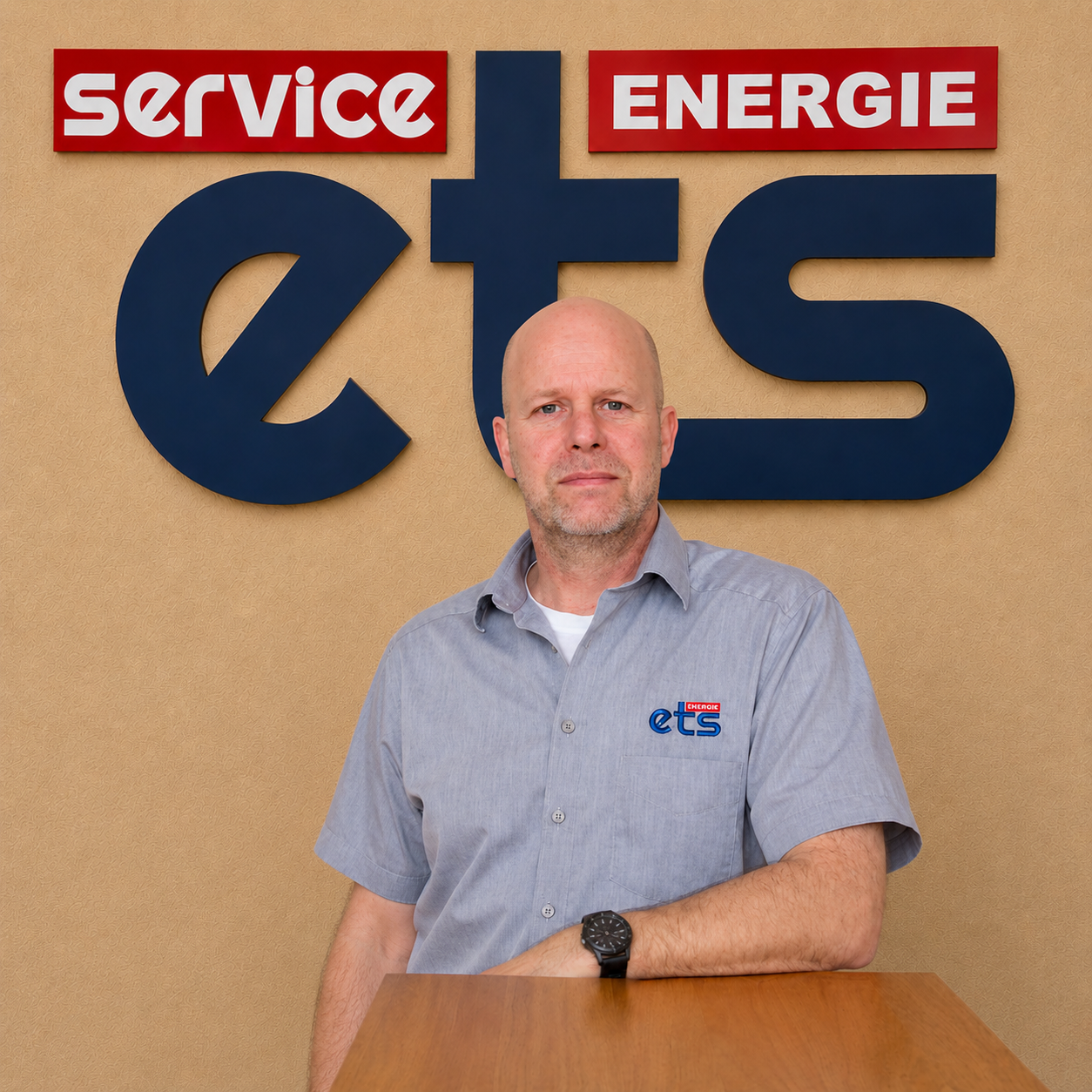 Mitarbeiter der Firma ets Energie Service steht vor Firmenlogo