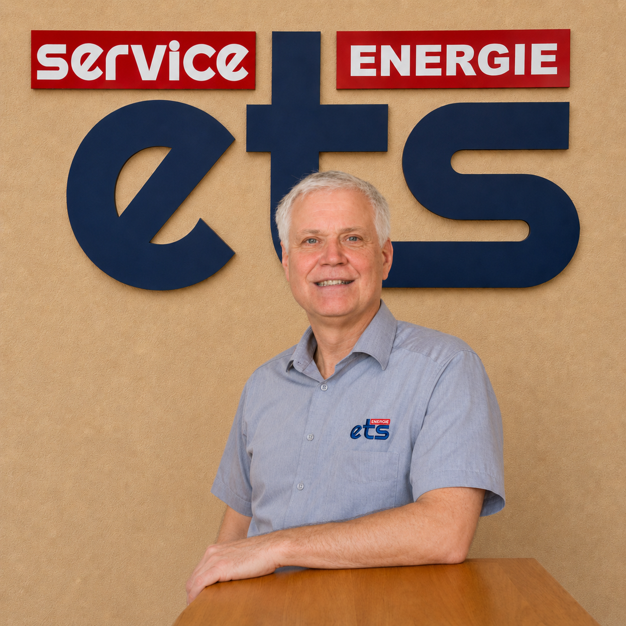 Mitarbeiter von ets Service Energie vor Logo-Wand