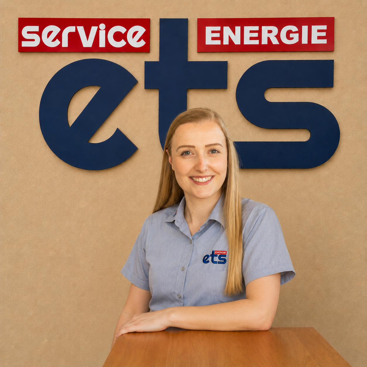 Mitarbeiterin von ets Energie Service vor Firmenlogo