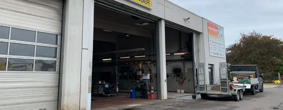 Innenansicht einer KFZ-Werkstatt mit geöffnetem Tor