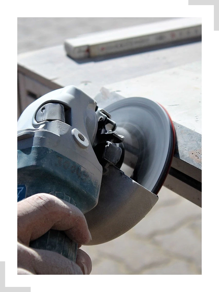 Bild mit Ecken hochkant – Fliesenfertigarbeiten mit Winkelschleifer für präzise Fliesenzuschnitte Bild mit Ecken hochkant bei Fliesenfertigarbeiten – Winkelschleifer schneidet Fliese präzise zu