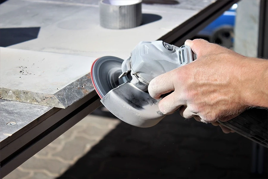 galerie-4: Handwerker schleift Metallplatte mit Winkelschleifer