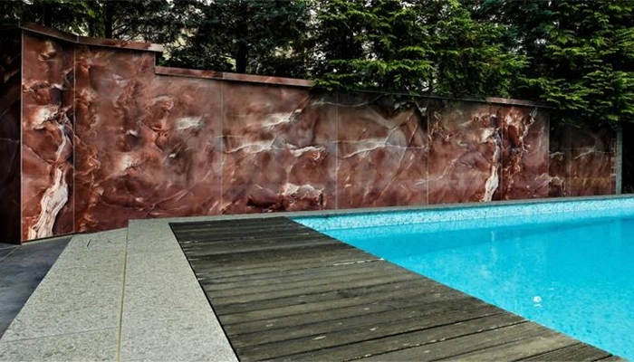 Fliesenarbeiten mit Megaformatplatten an einer Poolumrandung im Außenbereich