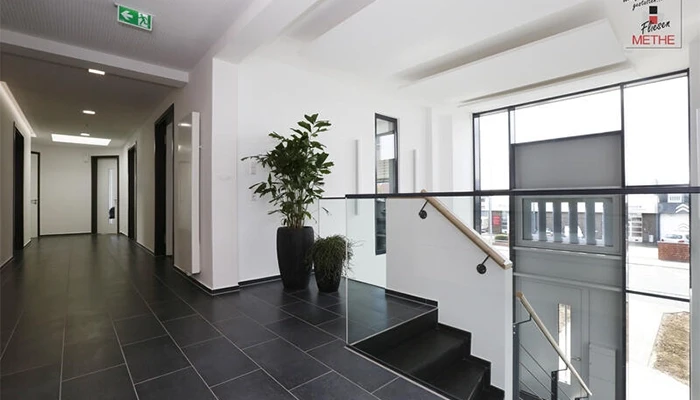 Moderne Fliesen im gewerblichen Objektbereich mit schwarzem Bodenbelag und heller Innenarchitektur