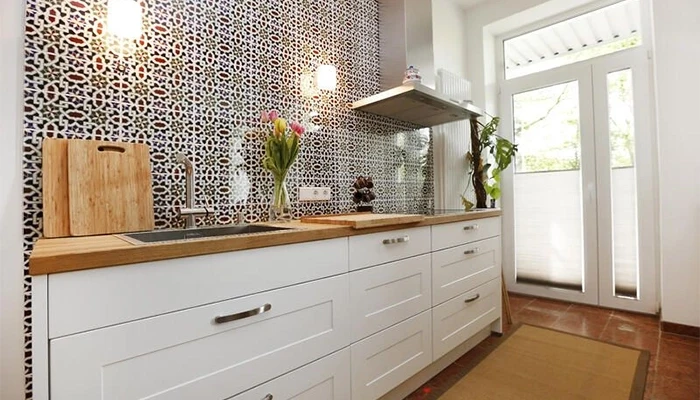 Moderne Küche mit Naturstein und spanischen Fliesen als Wandverkleidung