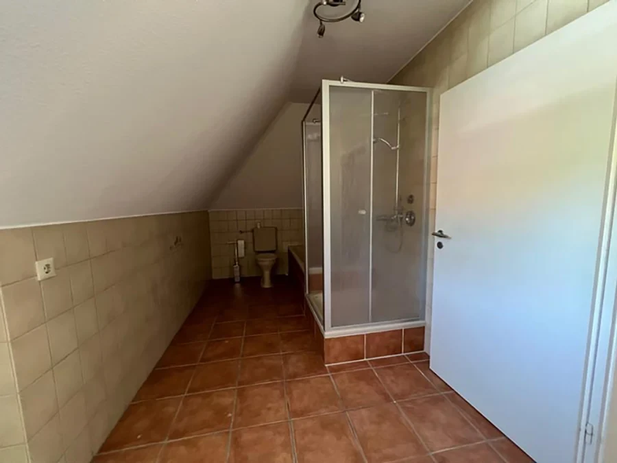 Badsanierung vorher: Altmodisches Badezimmer mit Dusche und Fliesen vor der Renovierung