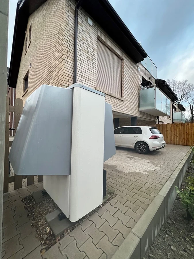 Luft-Wasser-Wärmepumpe von Bosch installiert in einem Einfamilienhaus mit gepflasterter Einfahrt