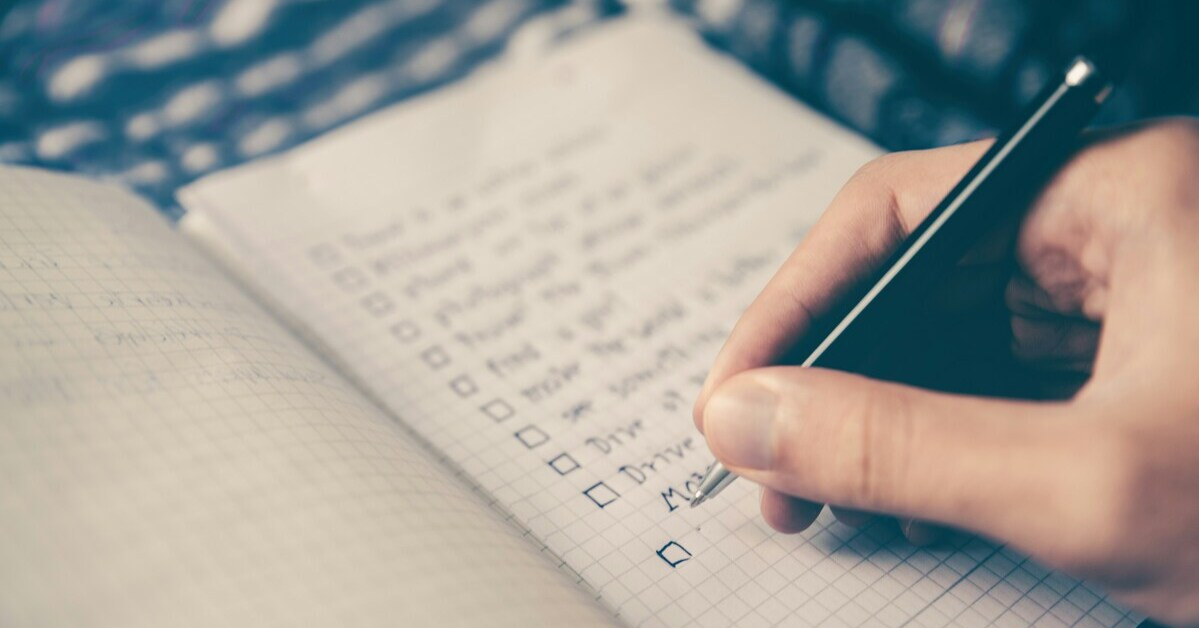 Umzugsplanung mit Checkliste – Hand schreibt To-Do-Liste fr den Umzug