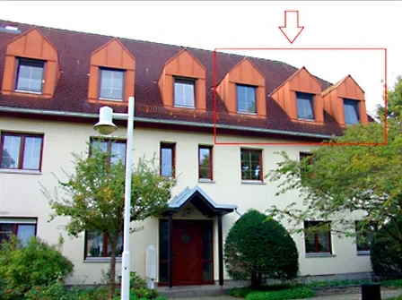 Großes Haus mit weißer Fassade und rotem Dach