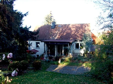 Weißes Haus mit rotem Dach und Garten