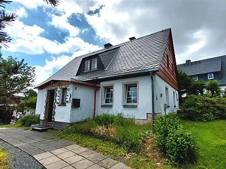 Weißes Haus mit braunem Dach, Garten und Steinweg