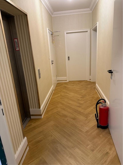 Renovierter Flur mit frisch gestrichenen Wänden und modernem Bodenbelag – Malerarbeiten Beispiel