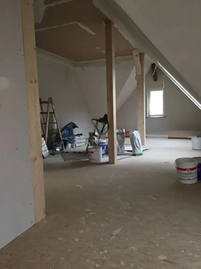 Energetische Sanierung eines Dachbodens mit Baumaterialien und Baustelle