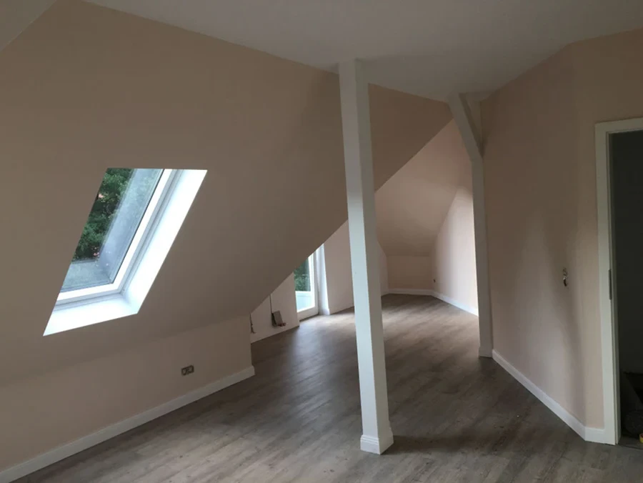 Energetische Sanierung eines Dachbodens mit modernem Dachfenster und neuem Bodenbelag