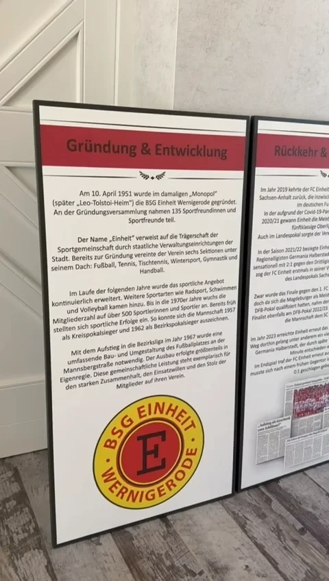 Infotafel zur Gründung und Entwicklung der BSG Einheit Wernigerode mit Vereinslogo
