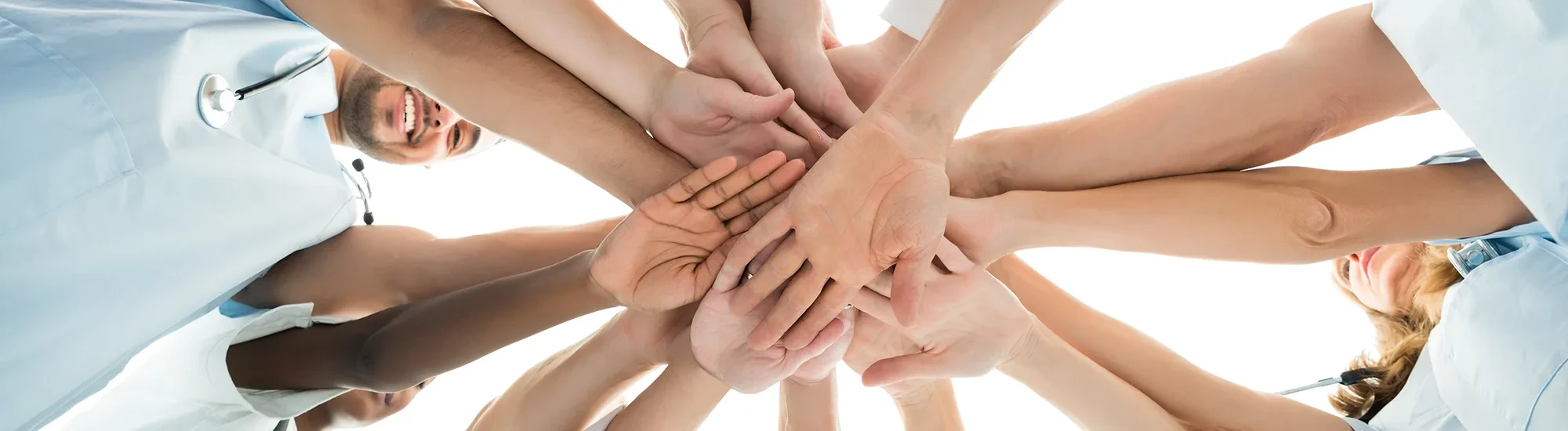 Viele Hände eines Teams als Symbol für Zusammenarbeit und Teamgeist