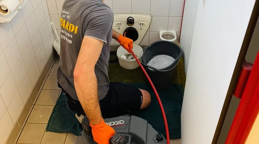 Rohrreinigung vom Profi – effektive Abflussreinigung im Badezimmer Fachmann bei der Rohrreinigung mit professionellem Gerät im Badezimmer