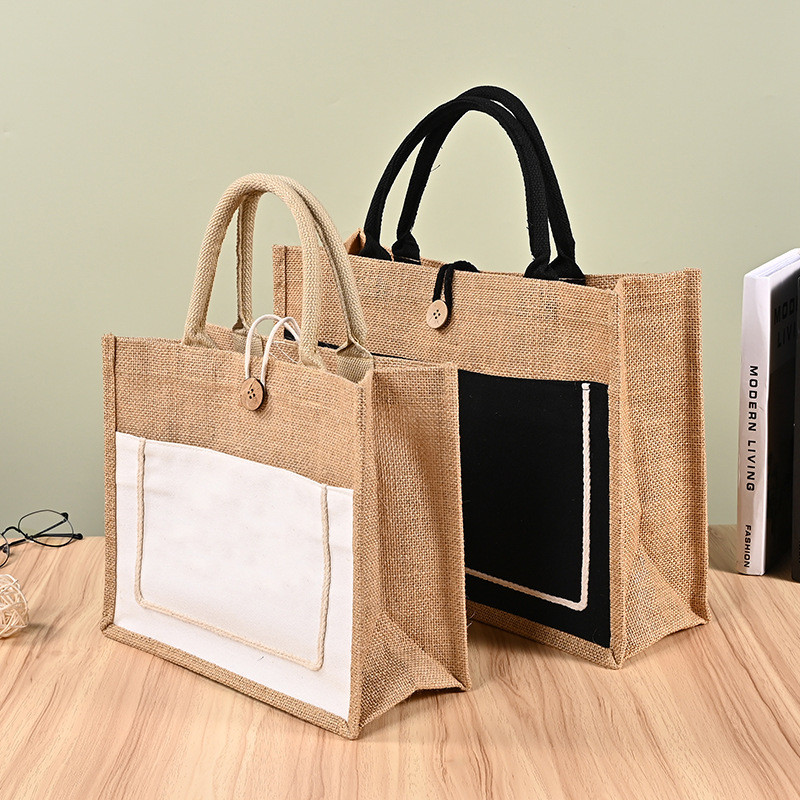 Zwei Jute-Baumwolltaschen mit weißen und schwarzen Fronttaschen auf einem Holztisch