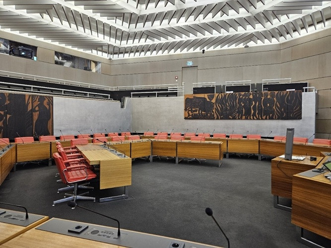 Moderner Ratssaal mit roten Stühlen und Konferenztischen in einem Sitzungssaal