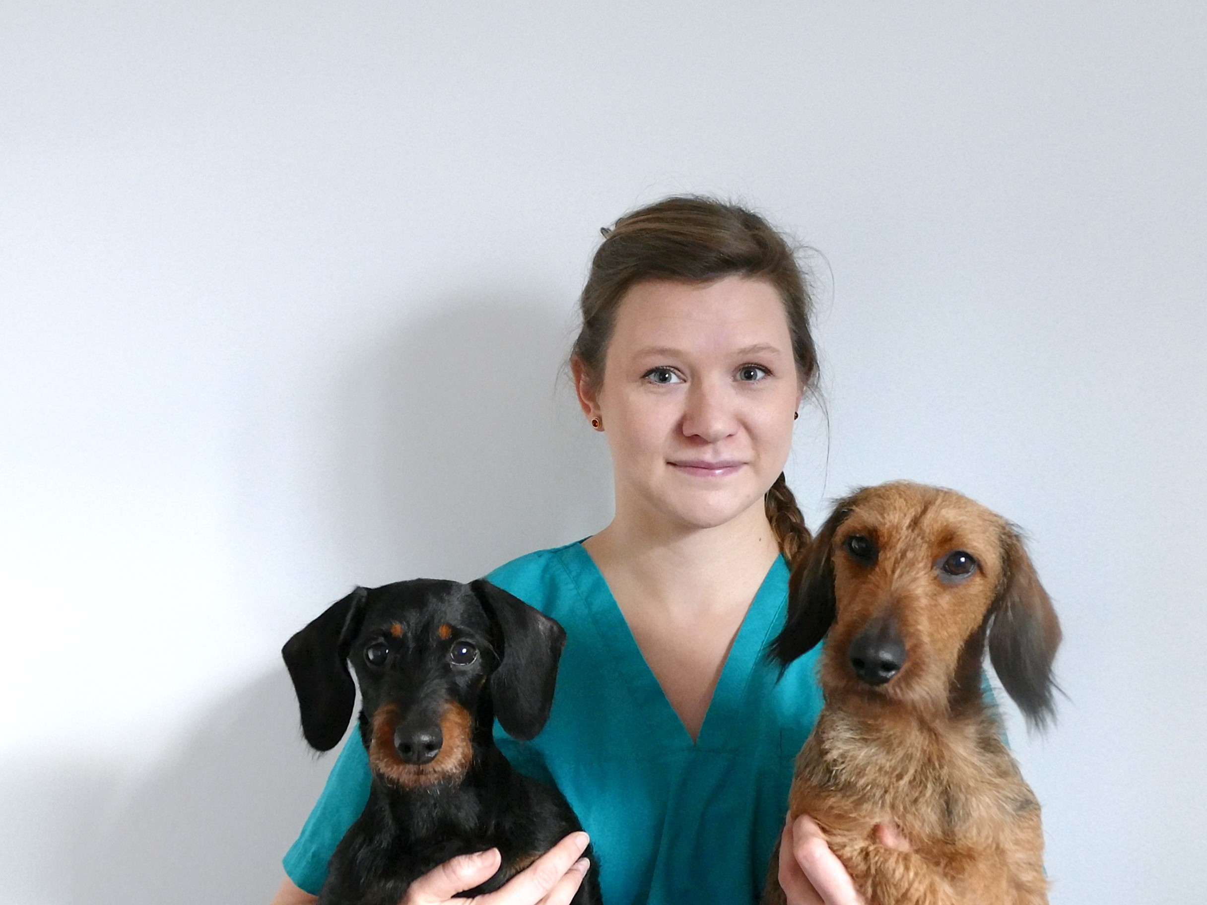 Dr. Lisa Herrmann in blauer Kleidung mit zwei Dackeln