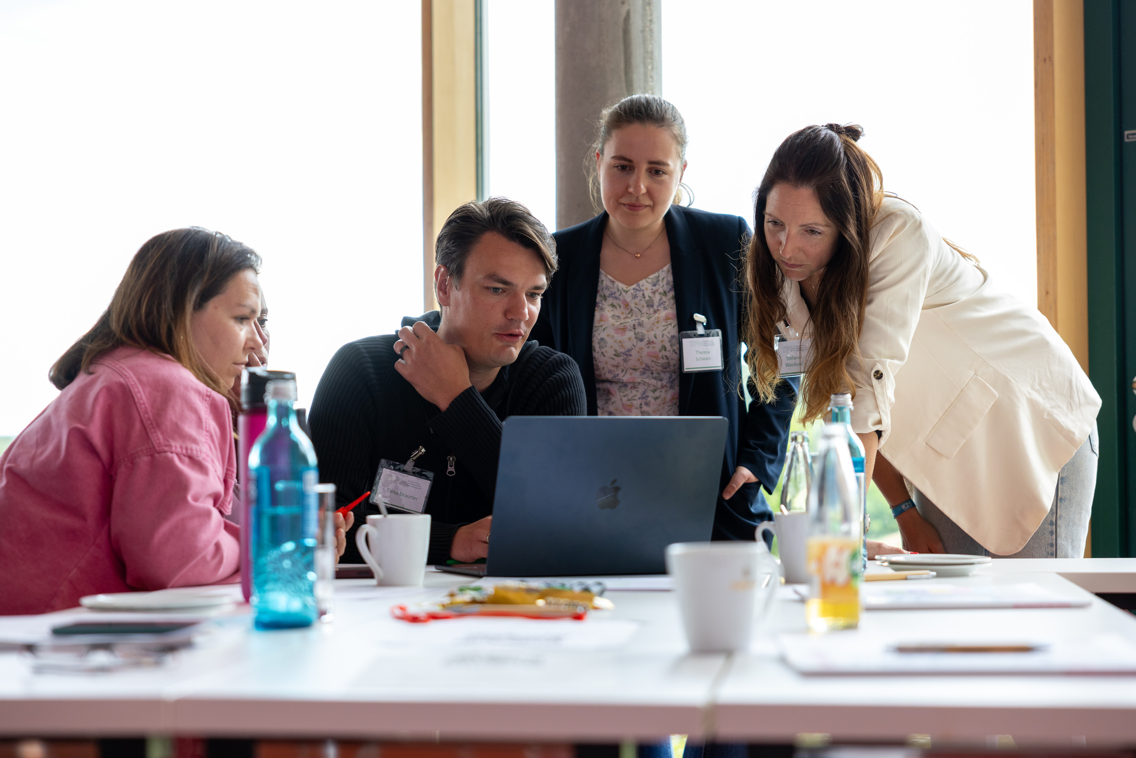 Gruppe von Menschen bei der Teamarbeit am Laptop