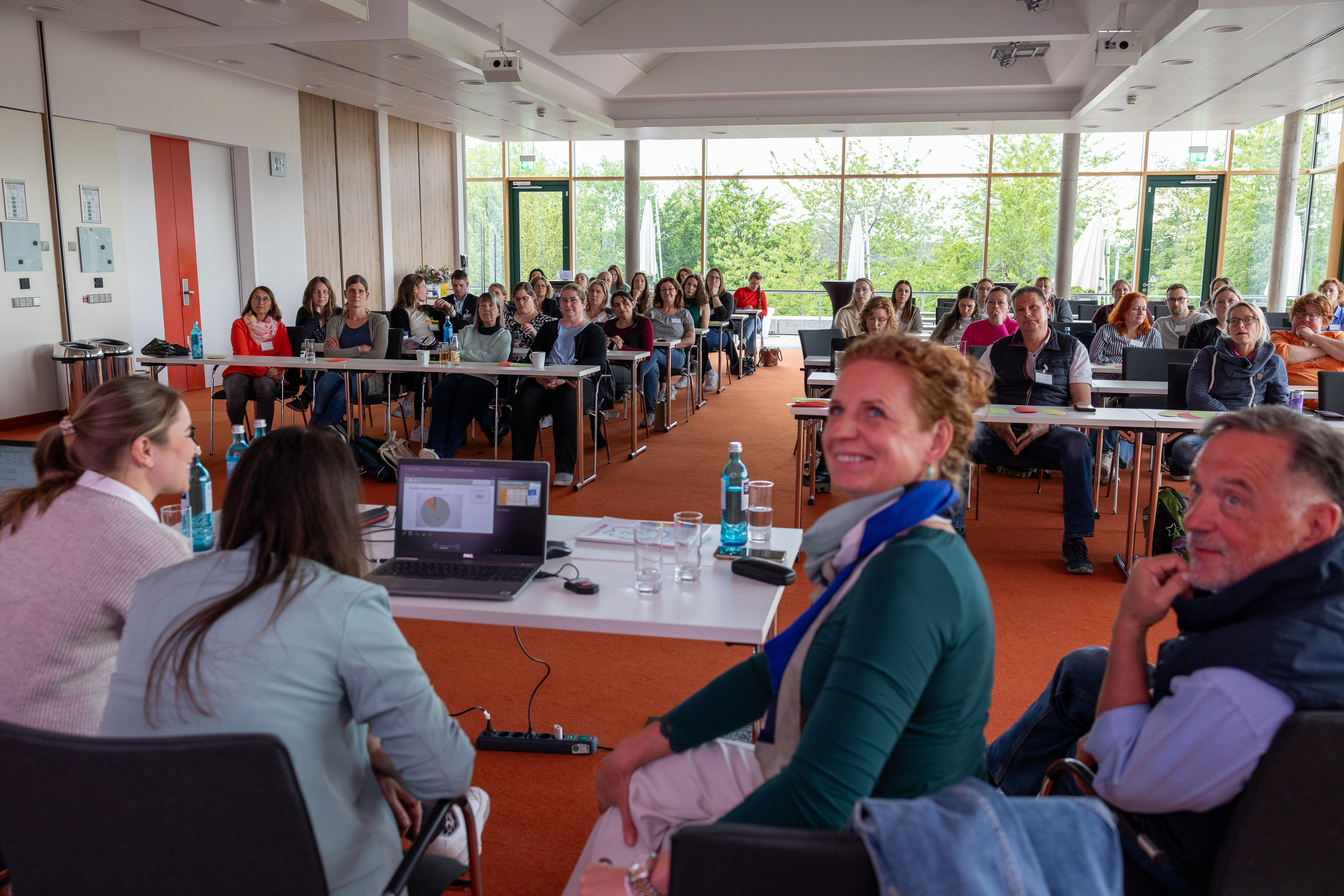 Teilnehmer eines Seminars in einem modernen Konferenzraum