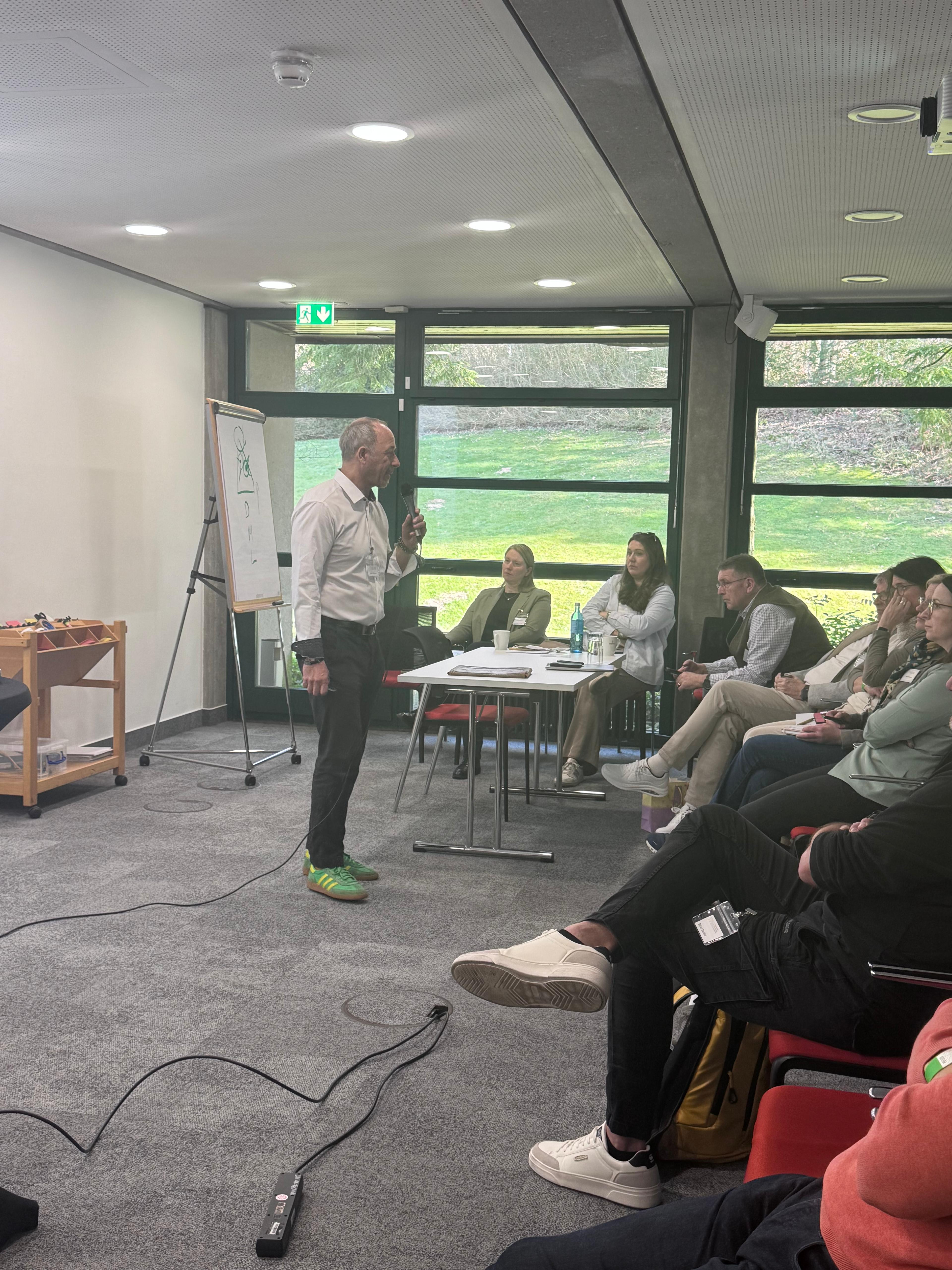 Workshop mit Vortragendem und Teilnehmern in einem modernen Seminarraum mit Flipchart