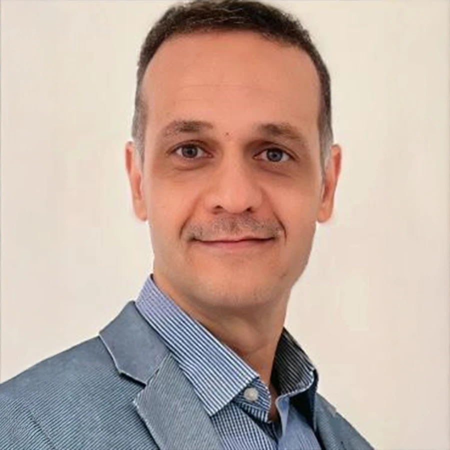 Porträt von Dr. Alighaeminia im Anzug vor hellem Hintergrund