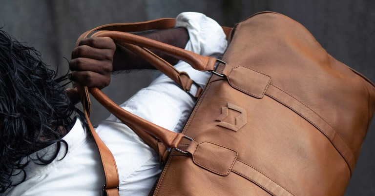 Taschen einseitig zu tragen kann Schmerzen verursachen Einseitig getragene braune Ledertasche an männlicher Hand