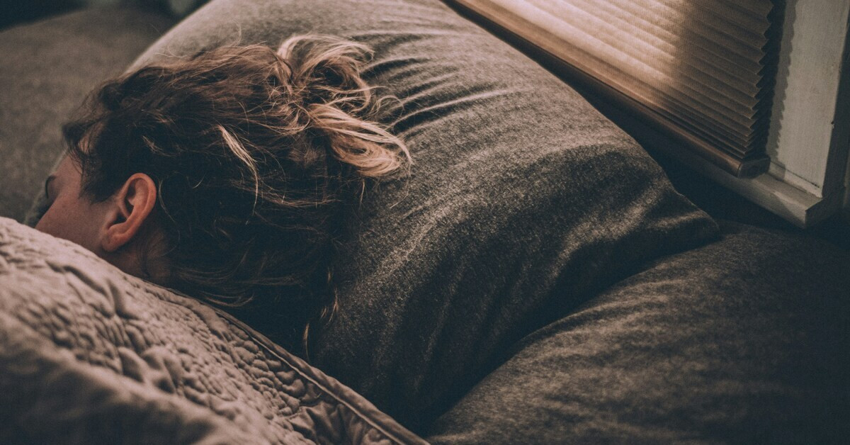 Frau liegt in ungünstiger Schlafposition, die Halsschmerzen verursachen kann