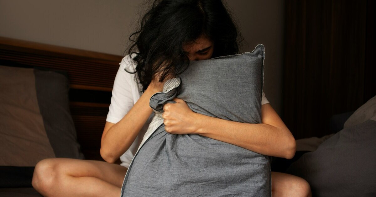 Frau hält verzweifelt ihr Kissen